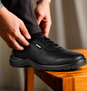 Primer plano de zapato ocupacional negro con acabado texturizado y cordones, ideal para largas jornadas de pie en oficinas.